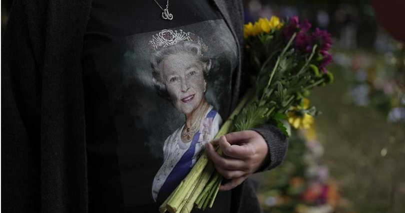 婦女在倫敦白金漢宮旁拿鮮花向女王致哀。