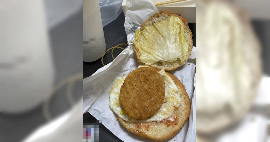 近日有名網友上傳了一張早餐店漢堡的照片，指出內餡僅1片蔬菜、1片加工肉片，以及1片煎過的蛋，這樣卻要價70元。（圖／翻攝自臉書爆廢公社二館）