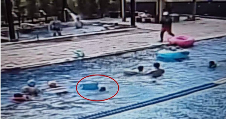 影片中的小朋友將泳圈脫掉，拿著浮板跳入泳池後隨即溺水。（圖／翻攝自臉書／《好想住飯店 好康.踩雷不藏私》）