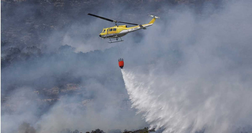 當局出動直升機在空中灑水，陸、空雙管齊下灌救滅火。（圖／達志／美聯社）